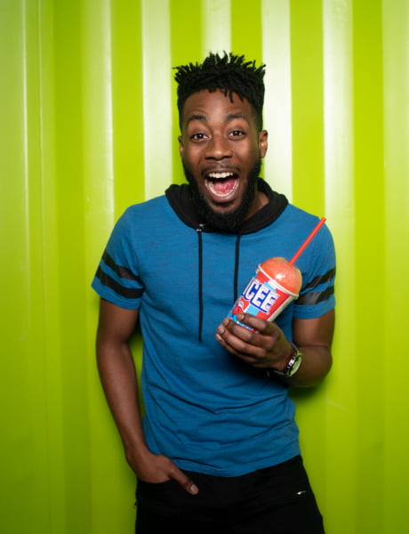 A man holding an ICEE and smiling excitedly